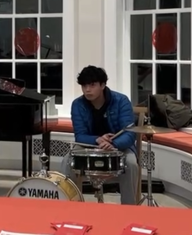A teenage boy playing drums