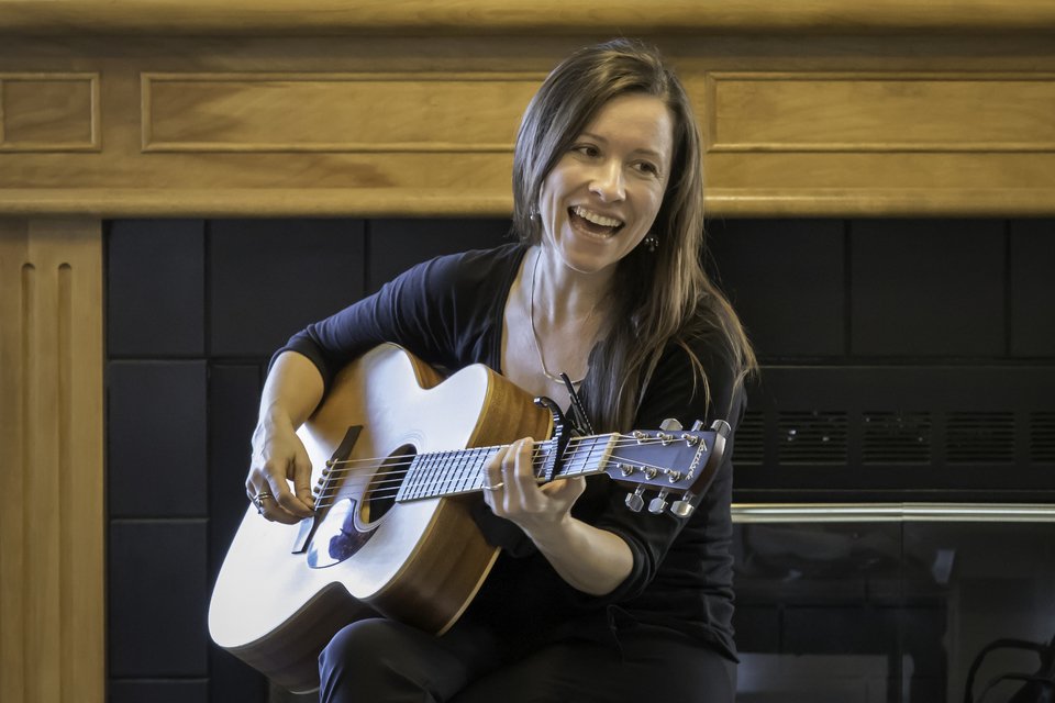 woman happily playing guitar