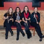 The flute section of YWES posing with their flutes after a concert in Robyn Newhouse Hall
