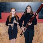 Two YWES students posing with their bassoon and oboe after a concert in Robyn Newhouse Hall