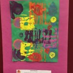 Prelude preschool art piece, magenta paper border, green paper in the middle with colorful painting on it