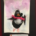 Prelude preschool art piece, penguin made with construction paper with watercolors in the background and a blue paper border