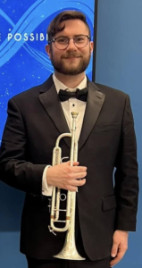 A man in a tuxedo standing and holding a trumpet